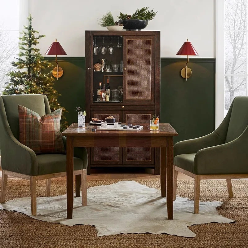 Dining room with wooden table, green chairs, and a decorated Christmas tree.