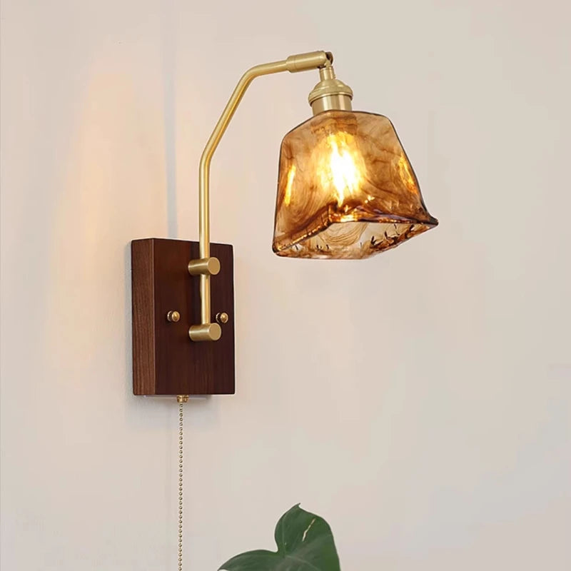 Wall-mounted lamp with brown glass shade and wooden base on a light gray background