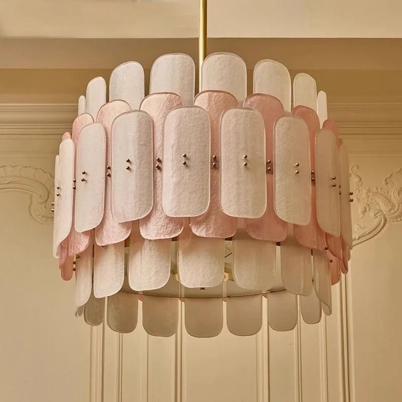 Chandelier with pink and white lampshades on a beige wall background