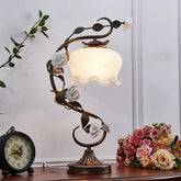 “French vintage table lamp with sculpted rose design and glass shade”