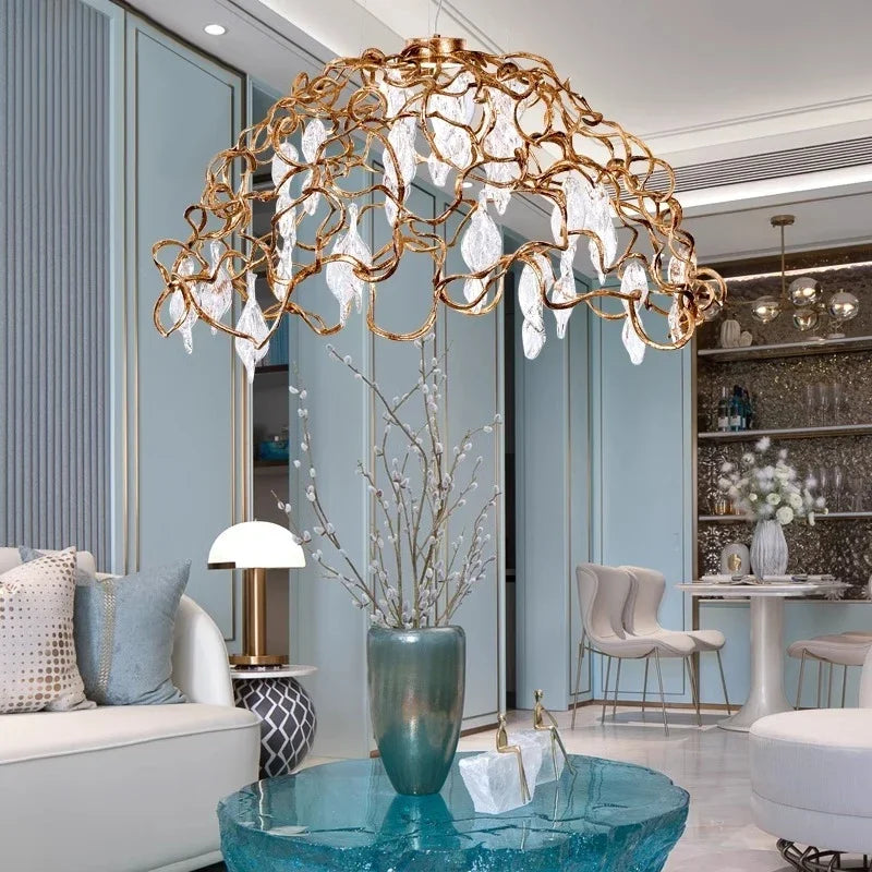 Luxury chandelier in a modern living room setting with a sofa, coffee table, and decorative elements.