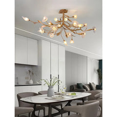 “Gold crystal chandelier with sculptural branches and flower accents”