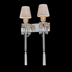 Decorative wall sconces with crystal details and white lampshades on a black background