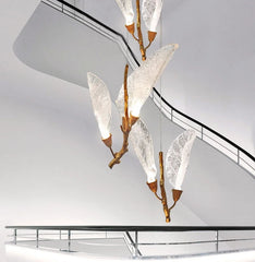 Long-drop leaf pendant chandelier cascading down a staircase space