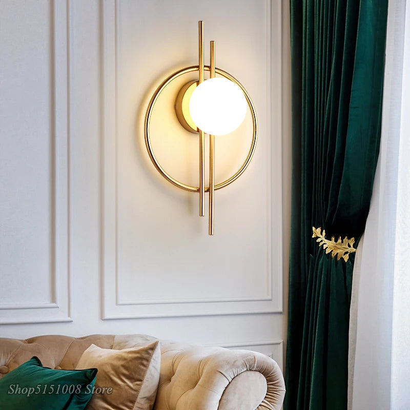 Modern wall lamp with gold finish and white bulb on a white wall with green curtains.