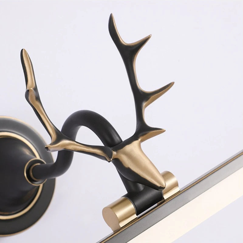 Decorative wall sconce with black and gold antler design on a white background