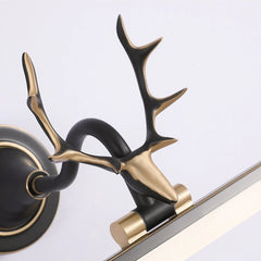 Decorative wall sconce with black and gold antler design on a white background