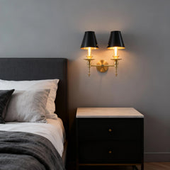 Modern bedroom with a bed, nightstand, and wall sconces.