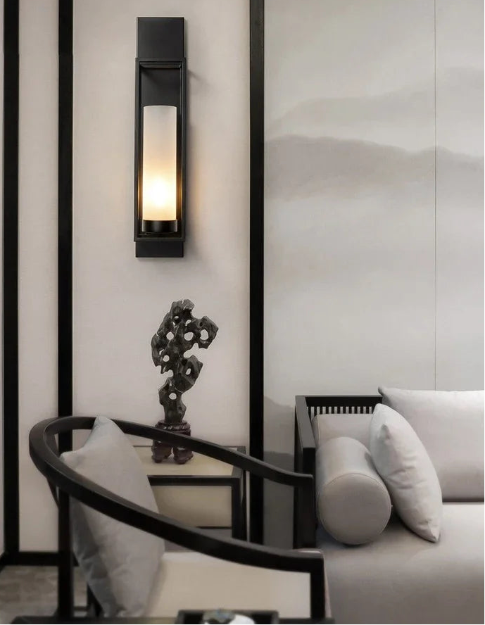 Modern interior design with wall sconce, sculpture, and sofa.