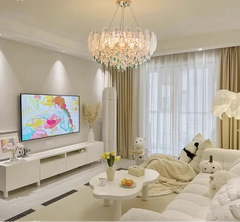 Modern living room with a chandelier, TV, and decorative items.