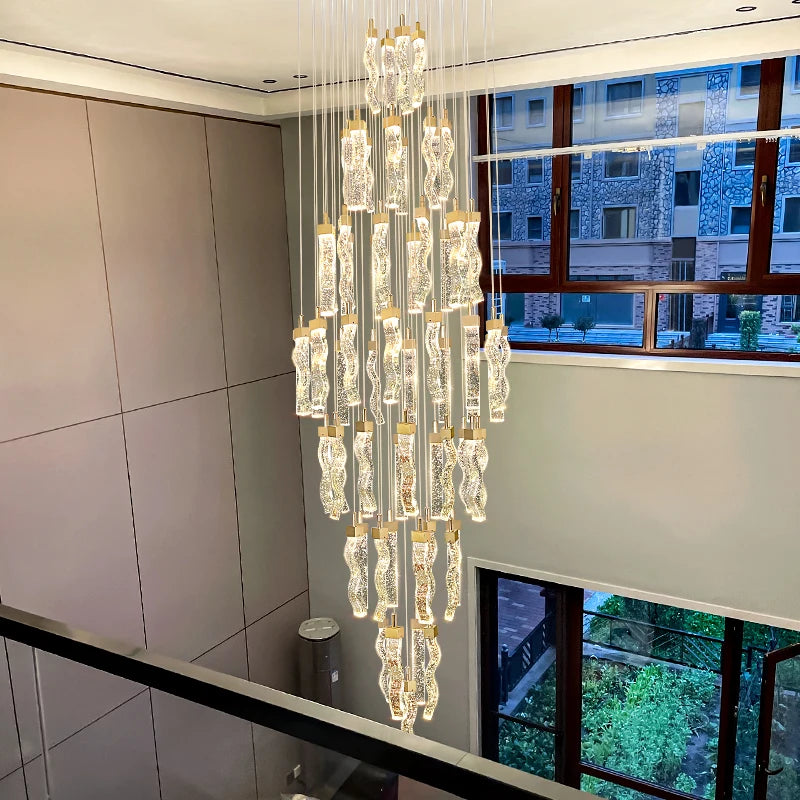 Double-height luxury chandelier centerpiece illuminating a contemporary staircase