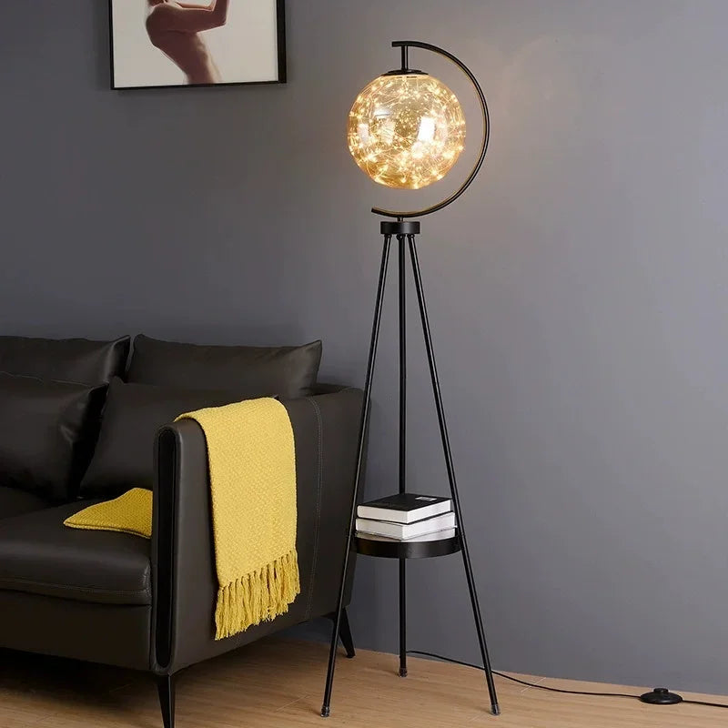 Floor lamp with a decorative glass shade in a living room setting. Contemporary Nordic floor lamp with tray and glass shade for home décor
