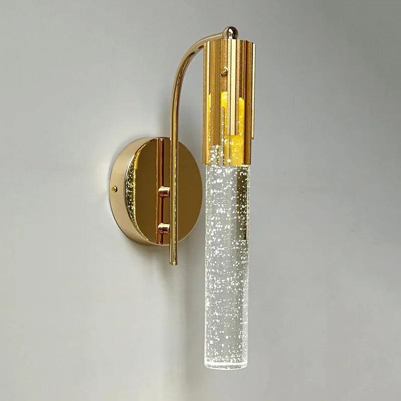 Gold wall sconce with clear glass on a gray background
