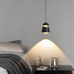 Minimalist bedside pendant light hanging above a nightstand area