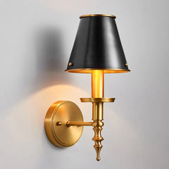 Wall-mounted lamp with black shade and gold base on a gray background