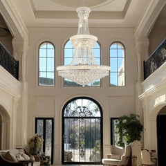 Modern empire-style crystal chandelier installed in a high-ceiling entryway
