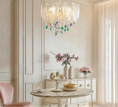 Decorative chandelier hanging above a table with floral arrangements in a stylish room.
