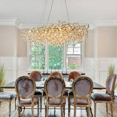 Dining room with a large chandelier, table, and chairs.