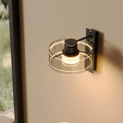 Modern wall-mounted light fixture with glass shade on a neutral wall.