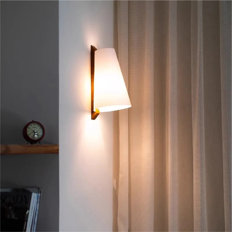 Wall-mounted lamp casting light on a curtain in a room setting