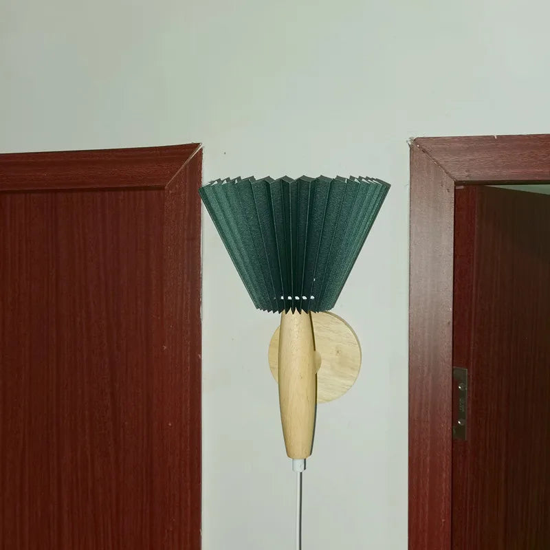 Green brush with wooden handle attached to a wall between two doors.
