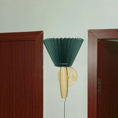 Green brush with wooden handle attached to a wall between two doors.