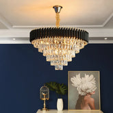 Chandelier hanging in a room with a blue wall, small table with decorative items, and a framed picture.
