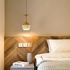Small Nordic-style pendant light hanging above a bedside table