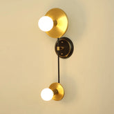 Gold wall sconce with two light bulbs on a beige wall