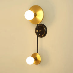 Gold wall sconce with two light bulbs on a beige wall