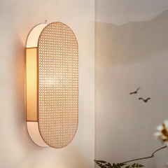 Woven wall light fixture on a neutral wall with a blurred background