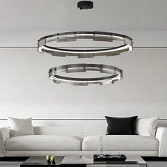 Modern pendant light fixture hanging above a white sofa in a living room setting.