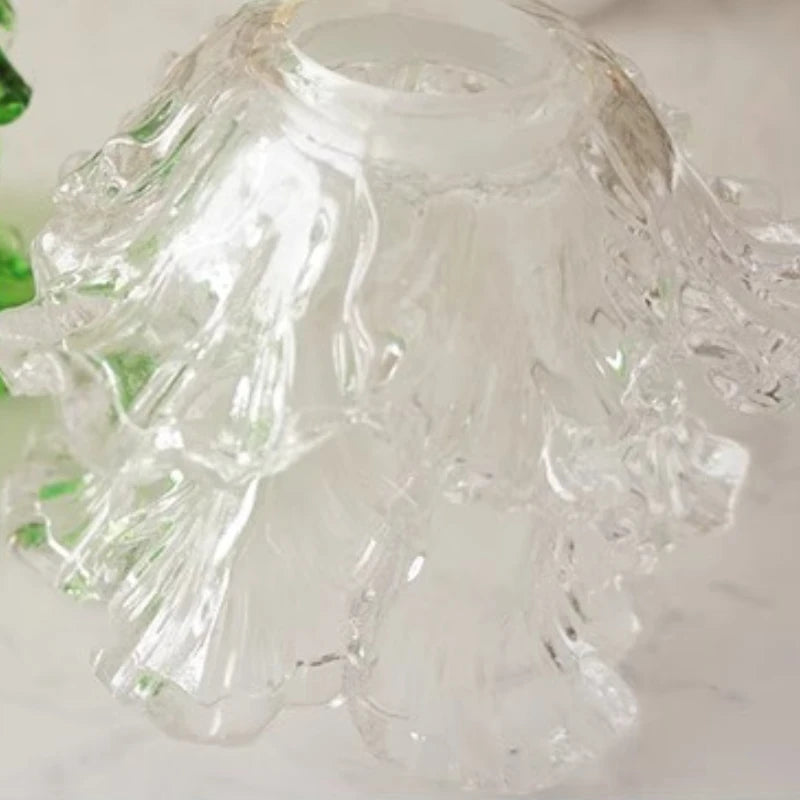 Clear glass object with green accents on a white background