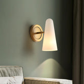 Wall-mounted lamp with a cone-shaped glass shade on a green wall.