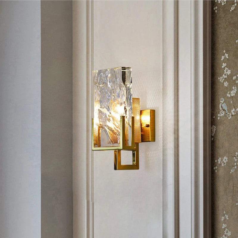 Decorative wall sconce with glass shade on a neutral wall.