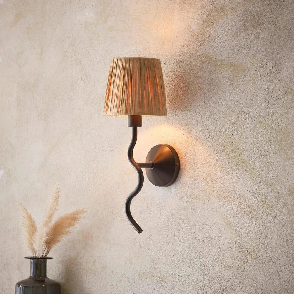 Wall-mounted lamp with a decorative shade on a textured wall.