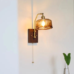 Wall-mounted lamp with a glass shade on a white wall
