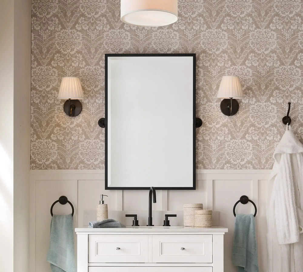 Bathroom with a white vanity, mirror, and decorative wall lights.