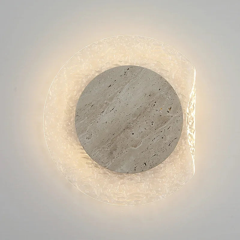 Round wall light fixture with stone-like texture on a white background