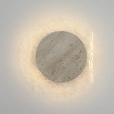 Round wall light fixture with stone-like texture on a white background