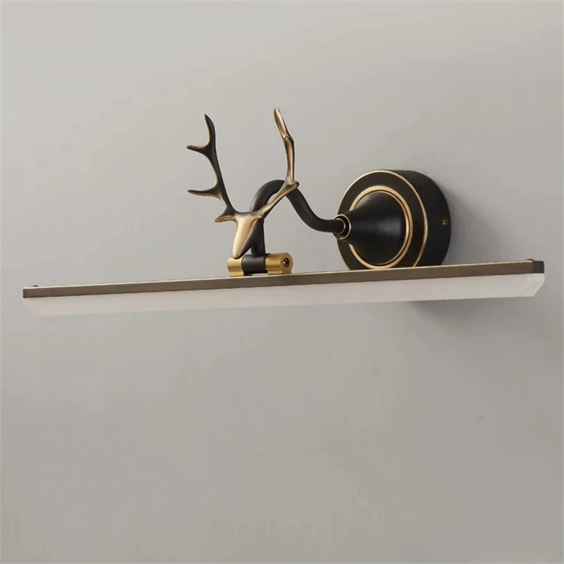Decorative wall light fixture with antler design on a plain background