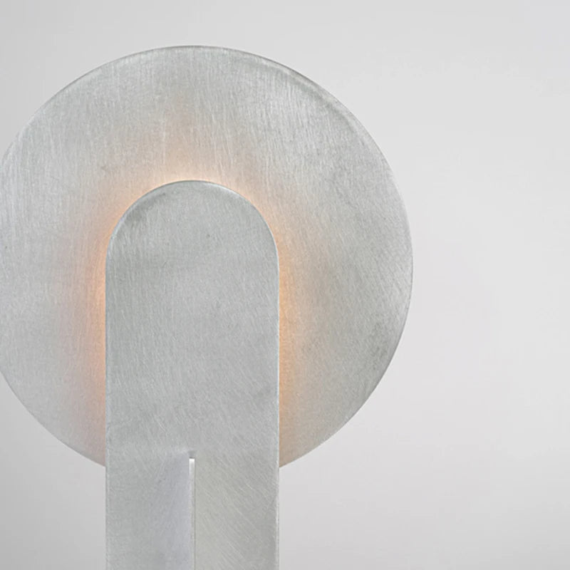 Modern wall sconce with a metallic finish on a light gray background