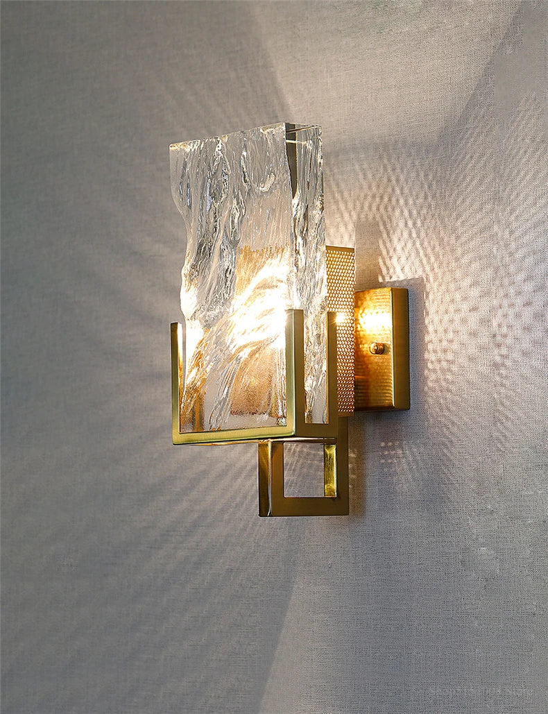 Modern wall sconce with marble-like finish on a textured wall.