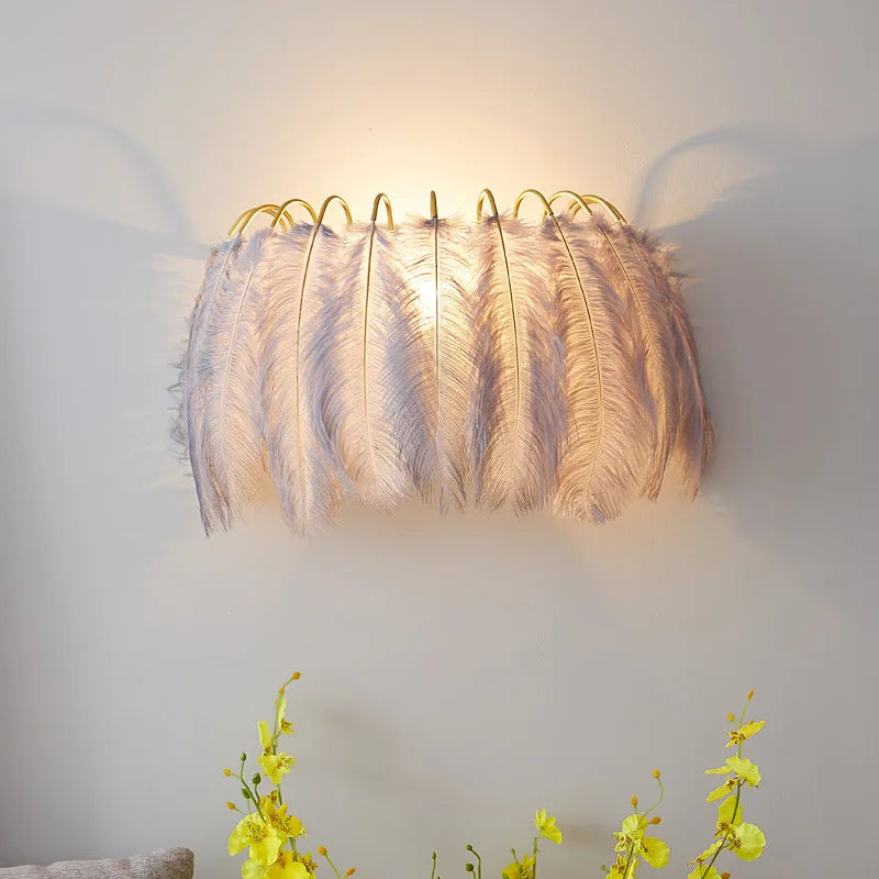 Gray feather wall sconce mounted on a wall, with yellow flowers in the foreground.