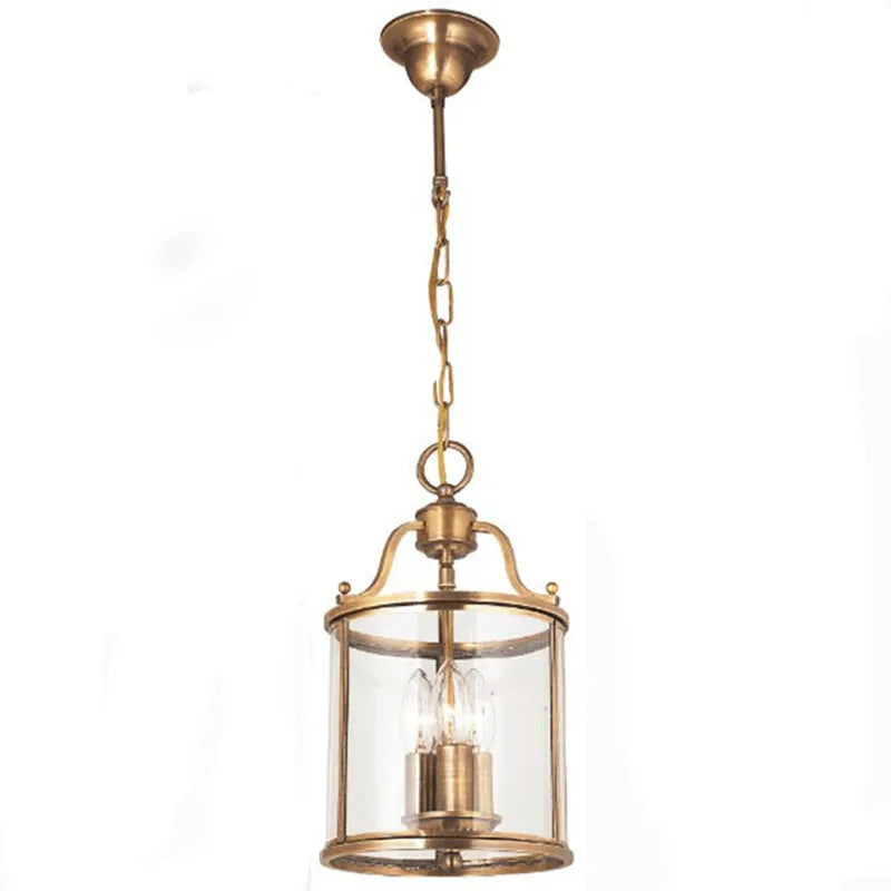 Close-up of a small brass cylinder glass chain pendant light against a white background