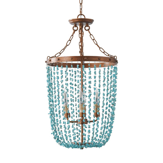 Turquoise stone bead chandelier with a distressed gold frame and three visible bulbs, isolated on a white background.