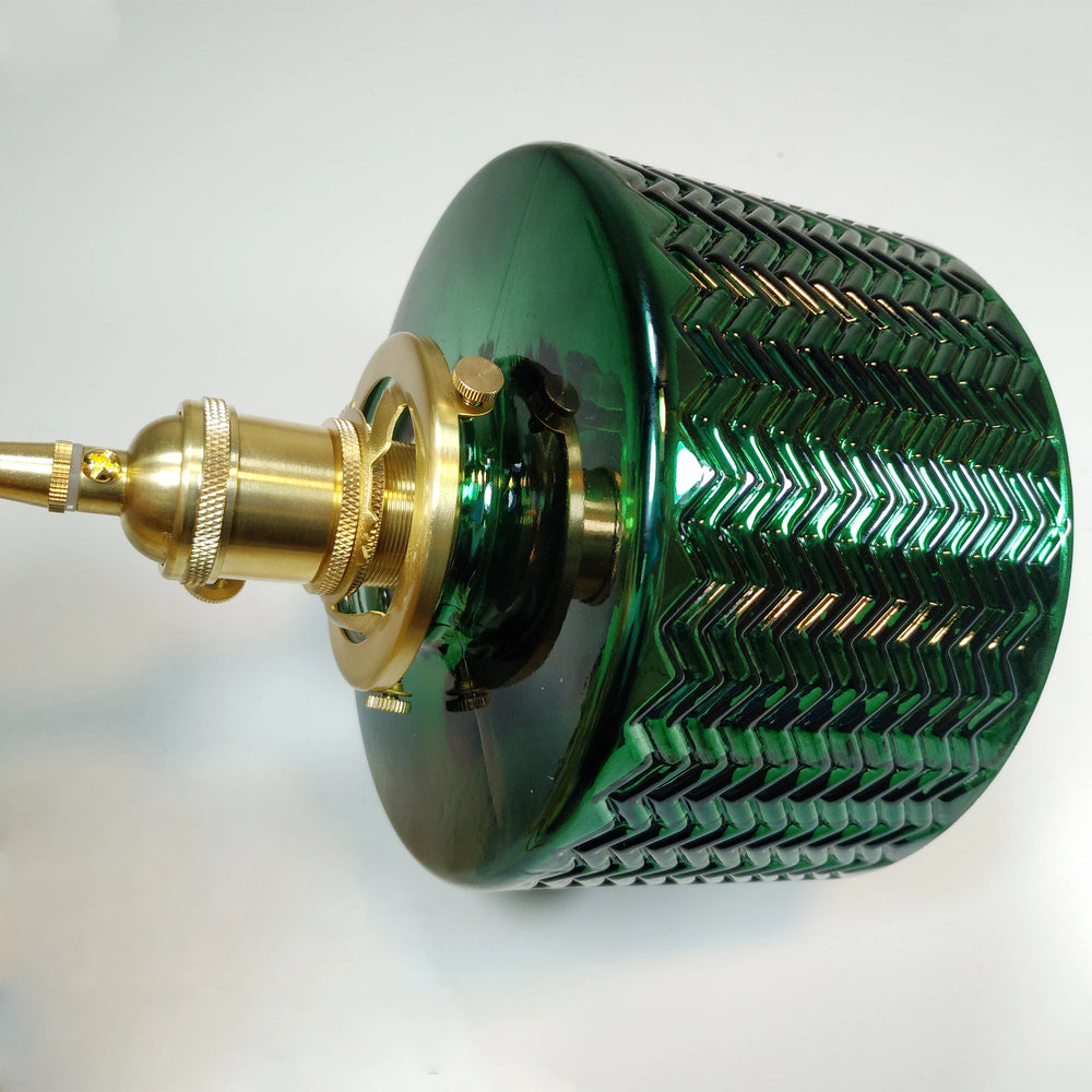 Close-up of a green fluted glass pendant light shade with brass hardware