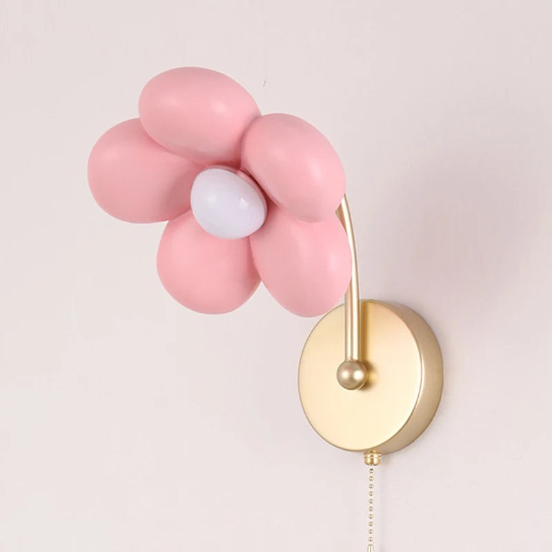 Wall lamp with pink flower-shaped lights and gold base on a light gray background