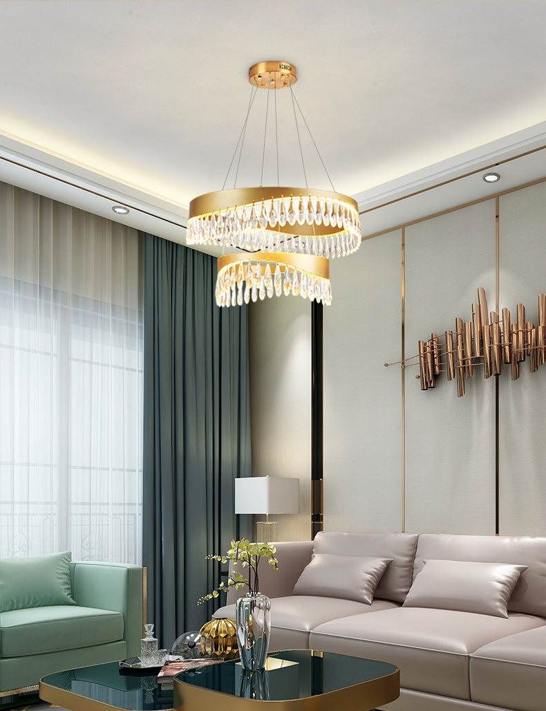 Modern living room with a chandelier, sofa, and decorative elements.