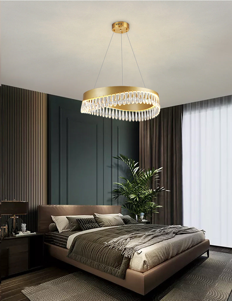 Modern bedroom with a chandelier, bed, and decor elements.